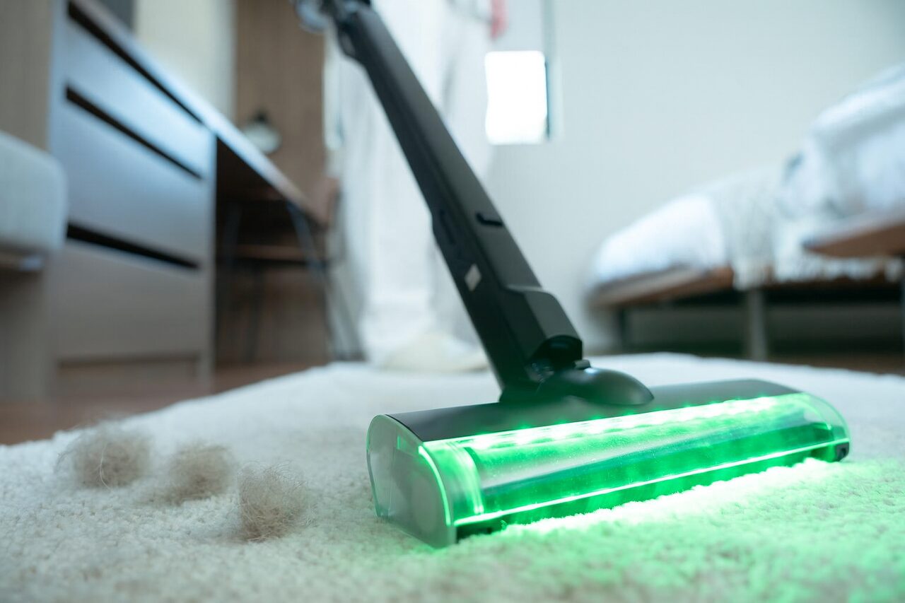 ラグの上に落ちたペットの毛を、SH-J002のヘッドが吸い取っているところ